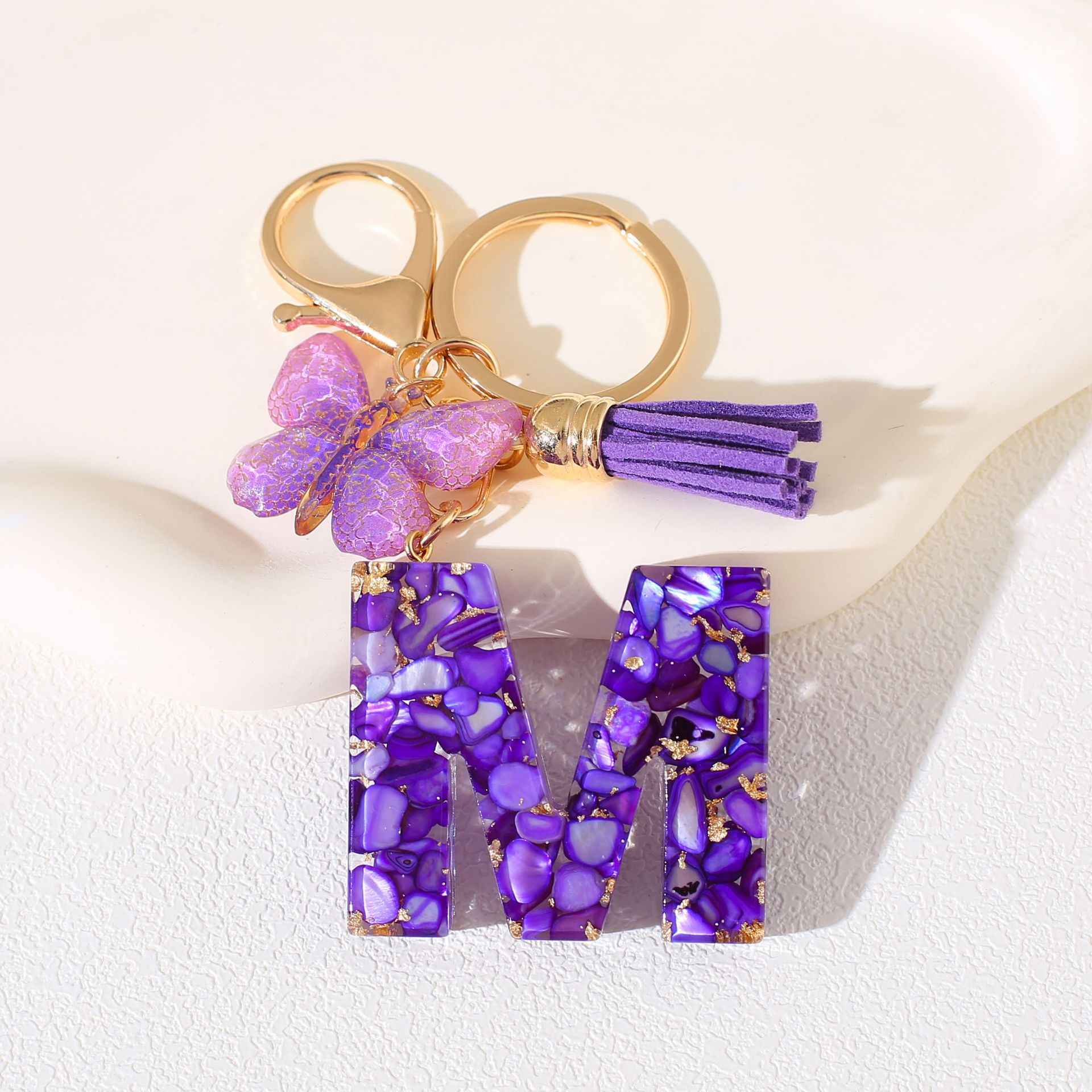 Fábrica directa de Yiwu accesorios de resina de goteo de embalaje llavero anillo de metal letras mariposa brilla colgante damas