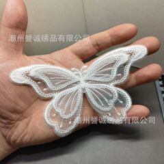 蝶の白いレースのコンピュータ刺繍の布は欧根紗の服装の補助材料を貼ってウェディングドレスのパッチの漫画を貼ります。