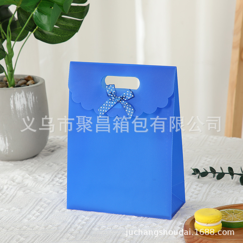 Bolsa de regalo con lazo multicolor, bolsa de mano de polipropileno con tapa abatible, bolsa de regalo con diseño hexagonal tipo ramo.