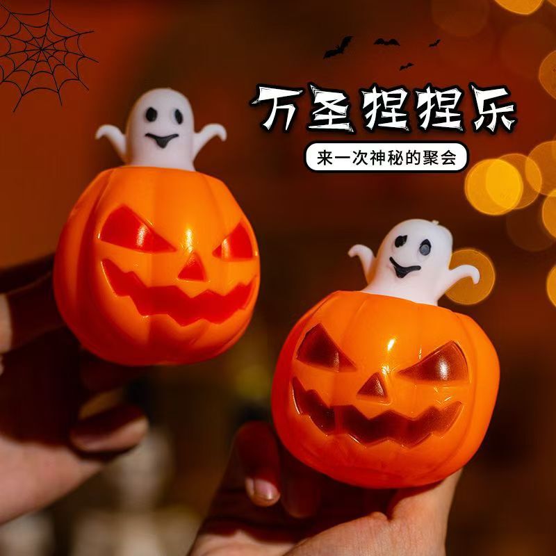 ハロウィーンの光るカボチャは杯を押して子供のおもちゃをつまんで解凍してカボチャの杯の夜市の露店の卸売りを発散します。|undefined