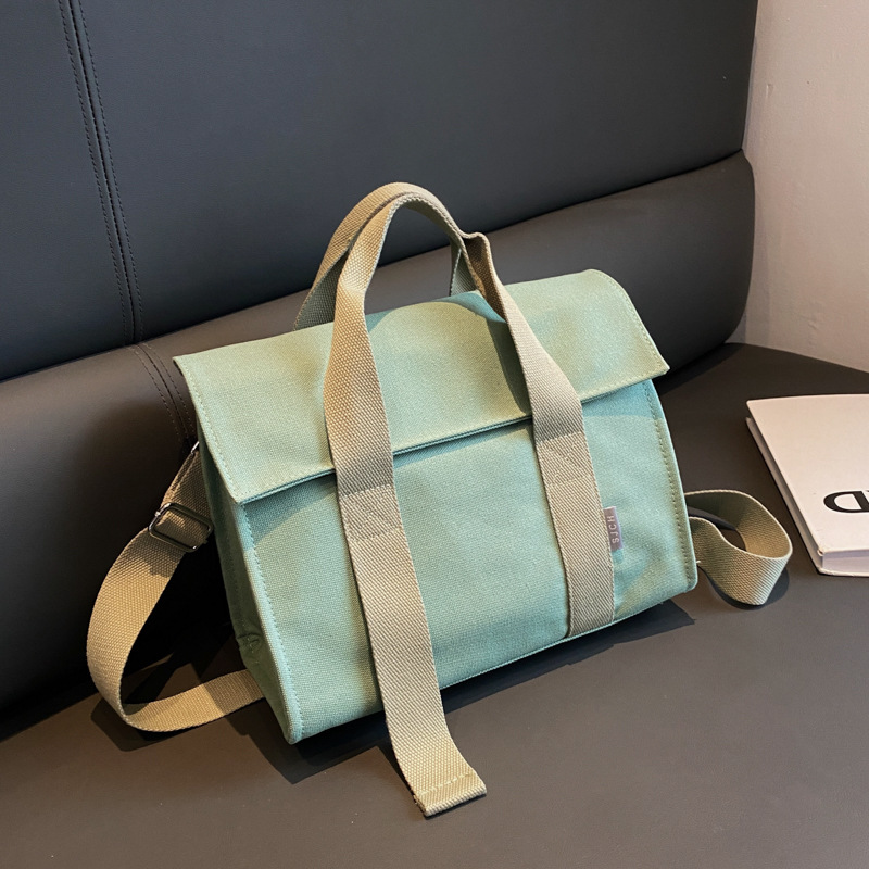 Comercio exterior bolsa de lona para las mujeres 2023 nueva moda japonesa y coreana bolsa de mano portátil nicho de alta calidad bolsa de mensajero del hombro