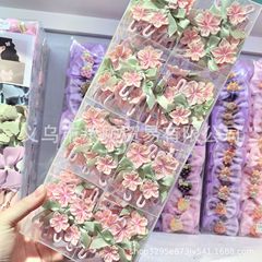 甘いレースの蝶結びのピンクの小さい桜の少女の写真のサイドは小学生の前髪を挟みます。