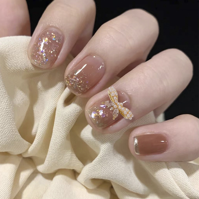 Uñas mariposa joyería nueva línea popular perla arco metal decoración de uñas pequeños accesorios de joyería al por mayor