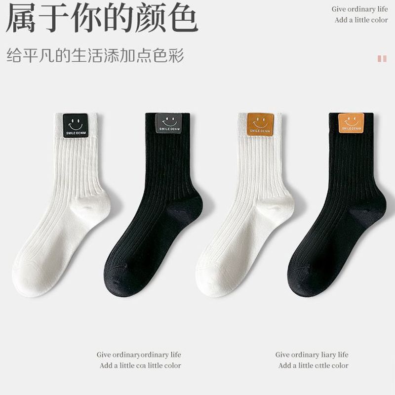Solid color mid-tube socks black white smiley face leather label autumn new ins tide Joker women's socks Zhuji socks wholesale