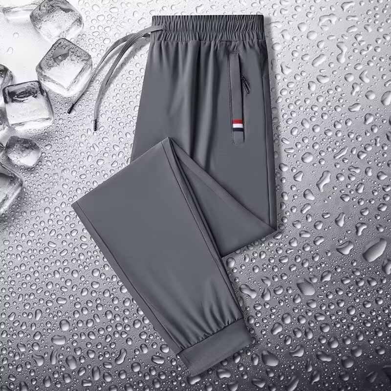 Camisas y menos ropa, pantalones de seda de hielo, pantalones de chándal elásticos finos de verano, pantalones rectos de hombre con cremallera de bolsillo al por mayor al por mayor