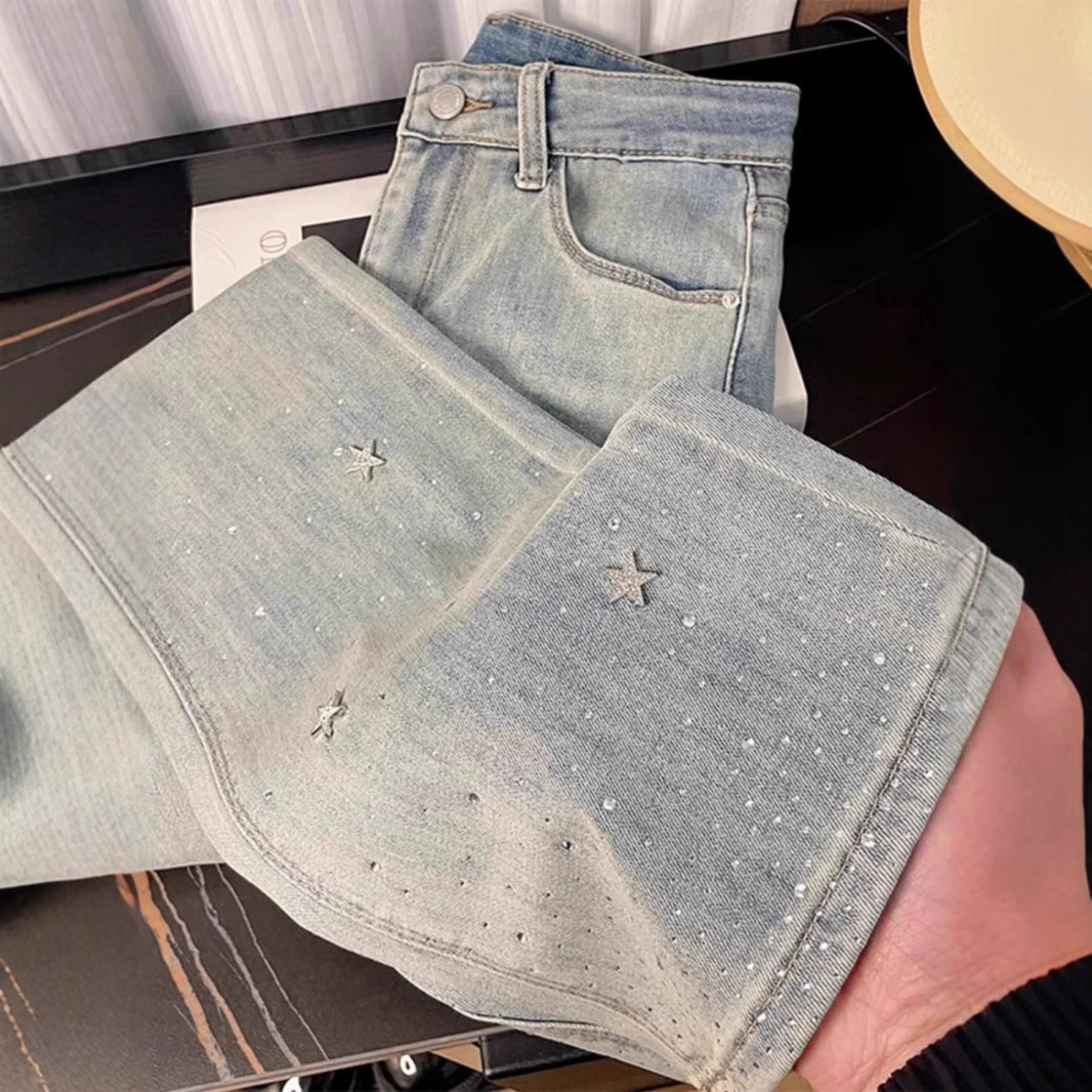 Calça jeans feminina de cintura alta com detalhes em estrelas e strass, modelagem flare, visual que afina a silhueta e favorece mulheres de estatura baixa. Jeans feminino da moda para a primavera._voghion.com