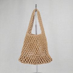 綿のビーチは休暇を過ごす綿の糸を包んで漁網のハンドバッグを編みます。