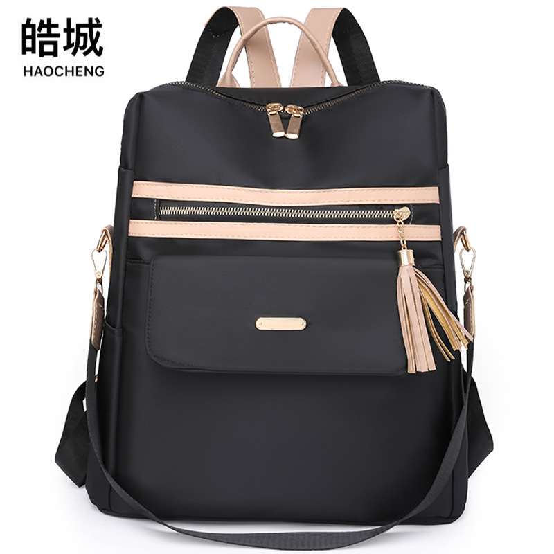 2023 nueva mochila casual para mujer nylon color contraste moda borla mochila de viaje multifuncional de doble uso al por mayor