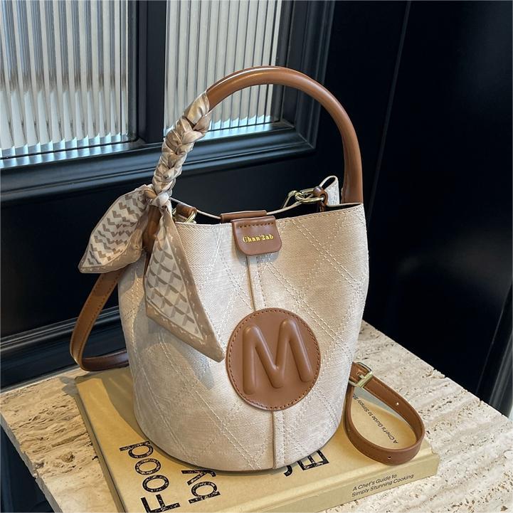 Bolso de mano popular de este año, dama, primavera y verano, 2026 nuevo bolso de cubo de vaquín universal, nicho de textura, mochila