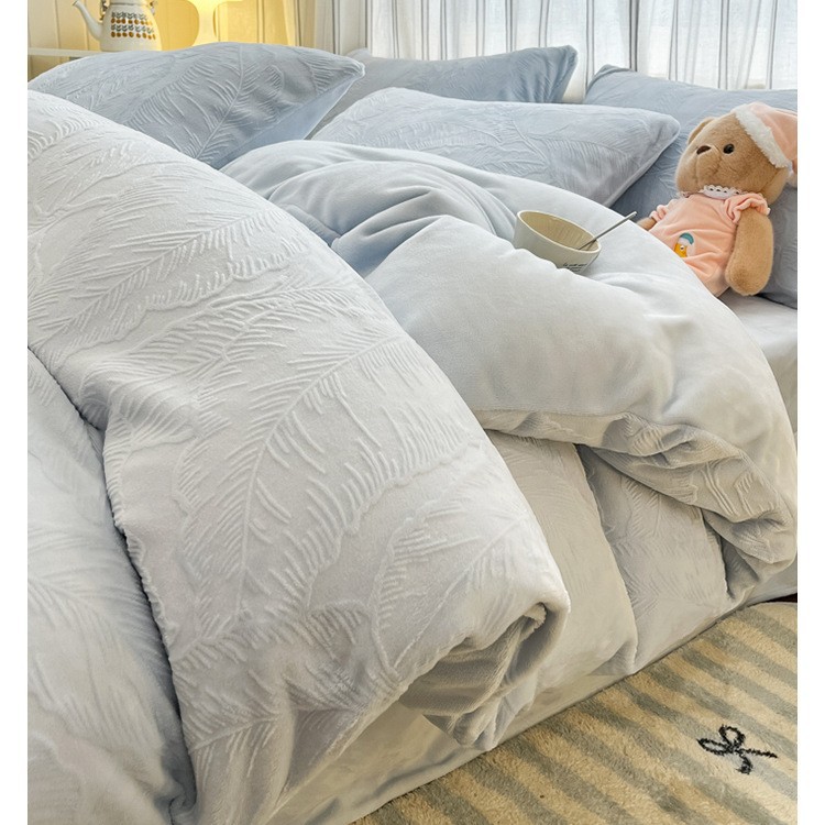 El conjunto de cuatro piezas de terciopelo de leche tallada otoño y invierno engrosado calentamiento 2025 nueva sábanas de terciopelo de coral cubierta de cama de tres piezas