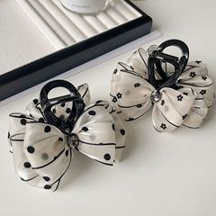 韓国系の波点の花の髪は女性の後頭部を挟みます。