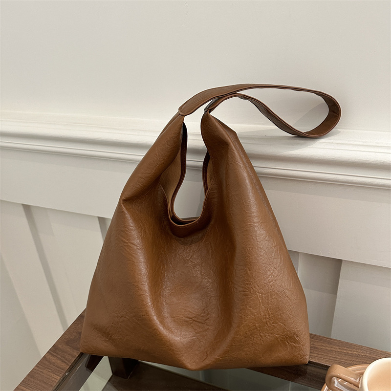 Bolso de mujer retro de gran capacidad de superficie suave casual 2024 nuevo estilo otoño e invierno bolso de hombro con patrón de agarre de mano moda bolso de cubo Tote