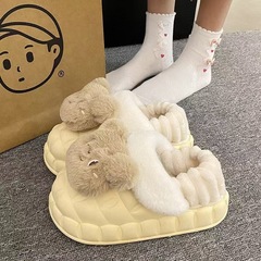 冬のかわいい毛羽立ちと綿のスリッパの女性は暖かくて滑り止めの綿の靴を履いています。