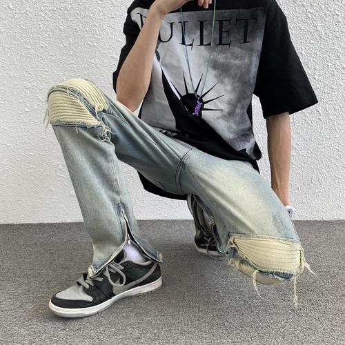 Euro-American trendy high-street light-blue distressed denim jeans for men: vintage-style, slim-fit, tapered legs, with zip-up cuffs—versatile and easy-to-match trousers