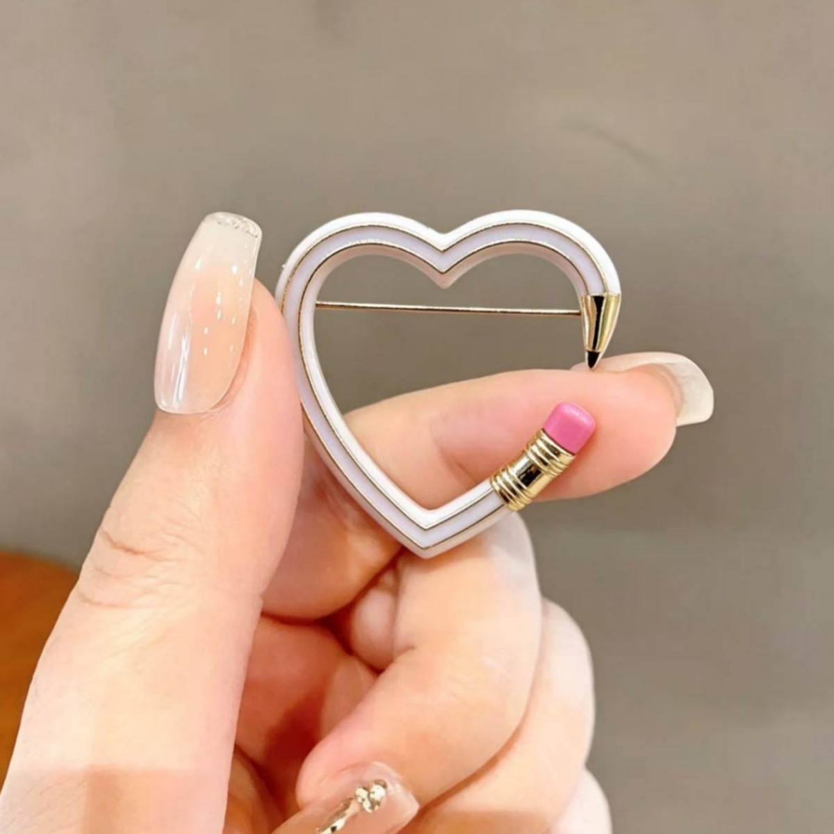 Cross-border best-selling creative heart-shaped pencil brooch, fun hollow-out enamel pin, niche cute item available for wholesale