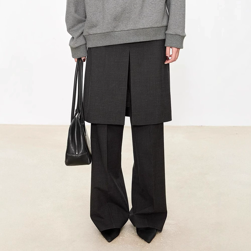 Модные женские широкие брюки-кюлоты в стиле минимализма 2025 года, имитирующие двухслойный дизайн с разрезом и расклешенным низом.