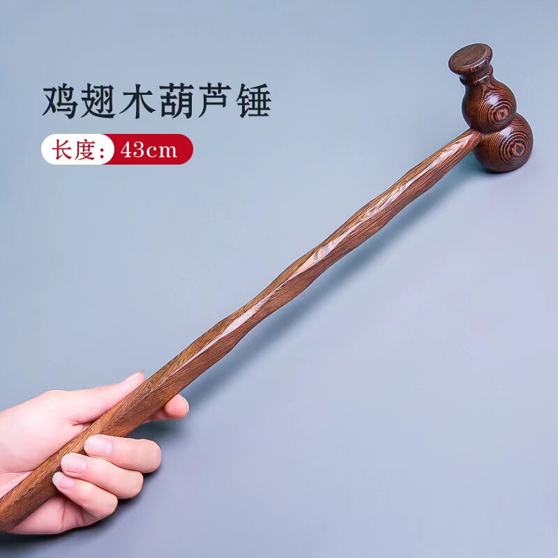黒い鶏の羽の木のマッサージのハンマーは背中をたたいてマッサージします。|undefined