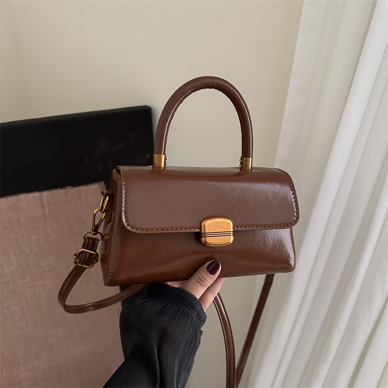 Nicho de diseño coreano bolso de mano 2025 primavera nuevo estilo simple de moda con cierre de flip de hombro monocolor bolso de mochila