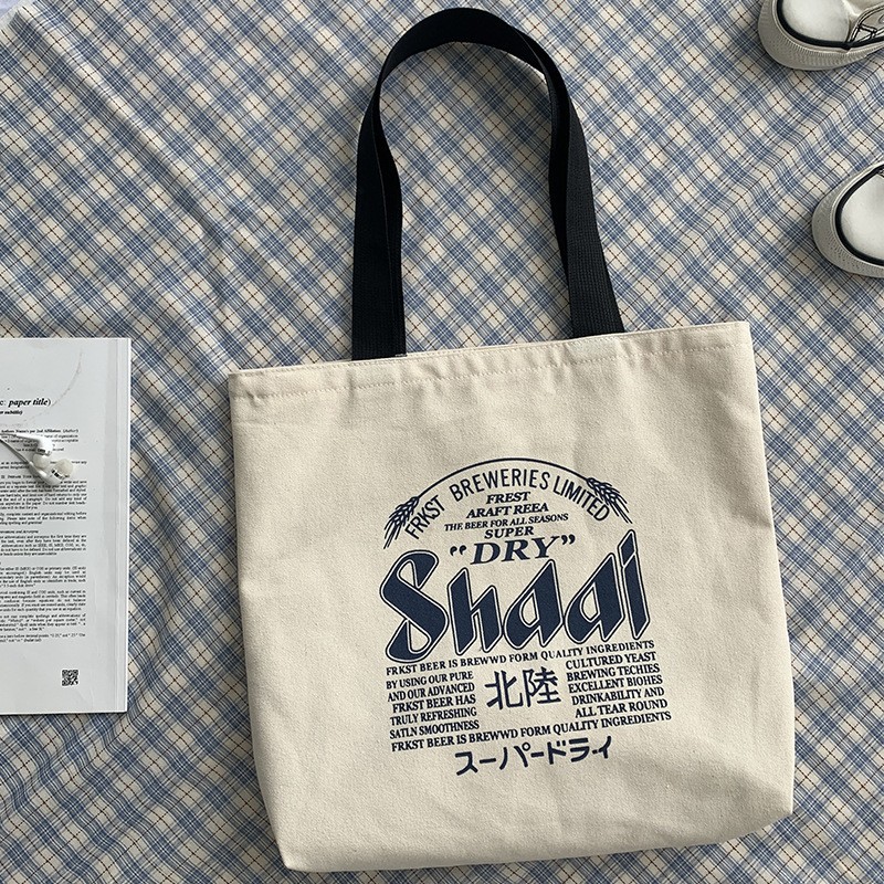 Bolsa de compras de lona de gran capacidad estilo europeo nuevo 2025 estilo ins perezoso para mujer, bolso de hombro para estudiantes, literario y simple.