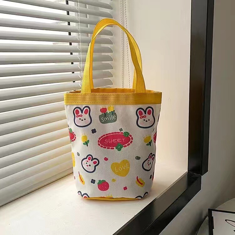 かわいい落書きバケツバッグinsプリント円筒バッグキャンバス弁当袋韓風少女は弁当箱を持っています。|undefined