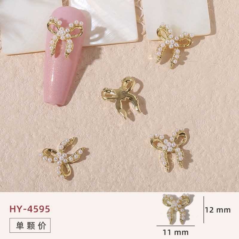 Uñas mariposa joyería nueva línea popular perla arco metal decoración de uñas pequeños accesorios de joyería al por mayor