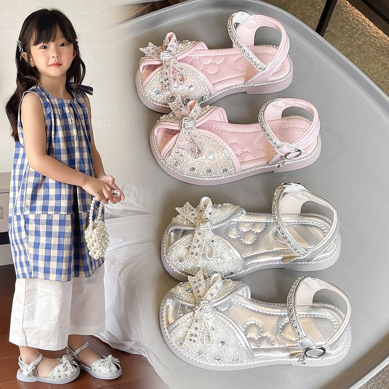 Sandalias Baotou para niñas 2025 verano nuevo estilo bowknot moda cristal princesa zapatos de playa para niños de suela suave marea
