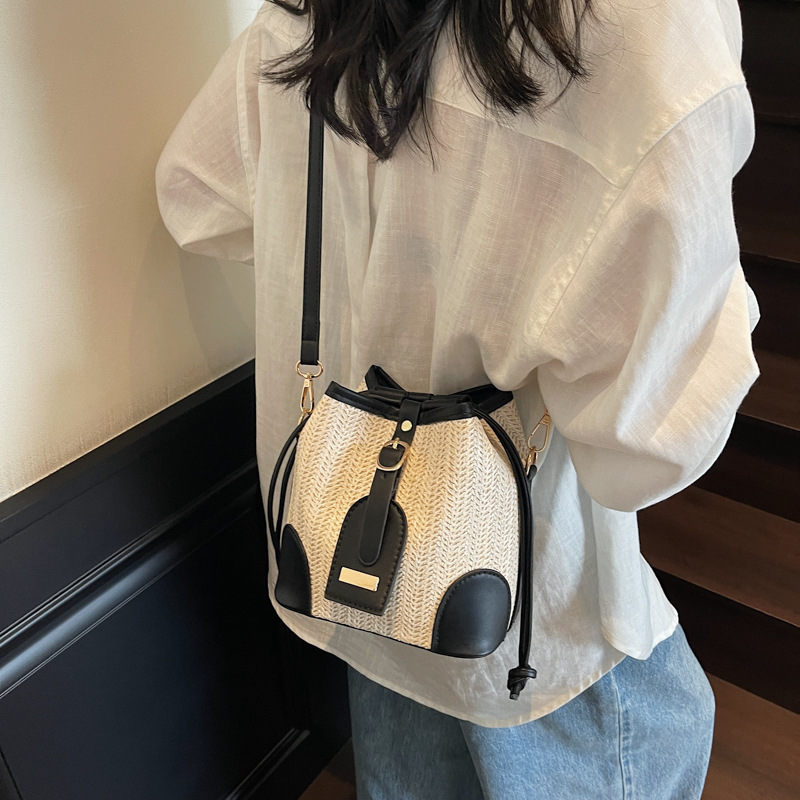 Bolso tejido femenino 2025 verano nuevo estilo juego junto al mar bolso de cubo de viaje tendencia bolsa de paja de mensajero de todo fósforo de nicho