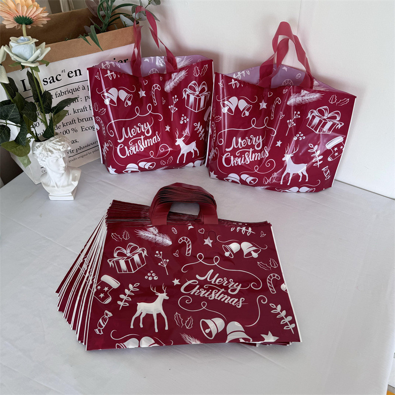 クリスマスの祝日の赤い厚手のプラスチックの贈り物の服の店は手提げの袋の包装で厚い買い物をして祝い事を包装します。|undefined