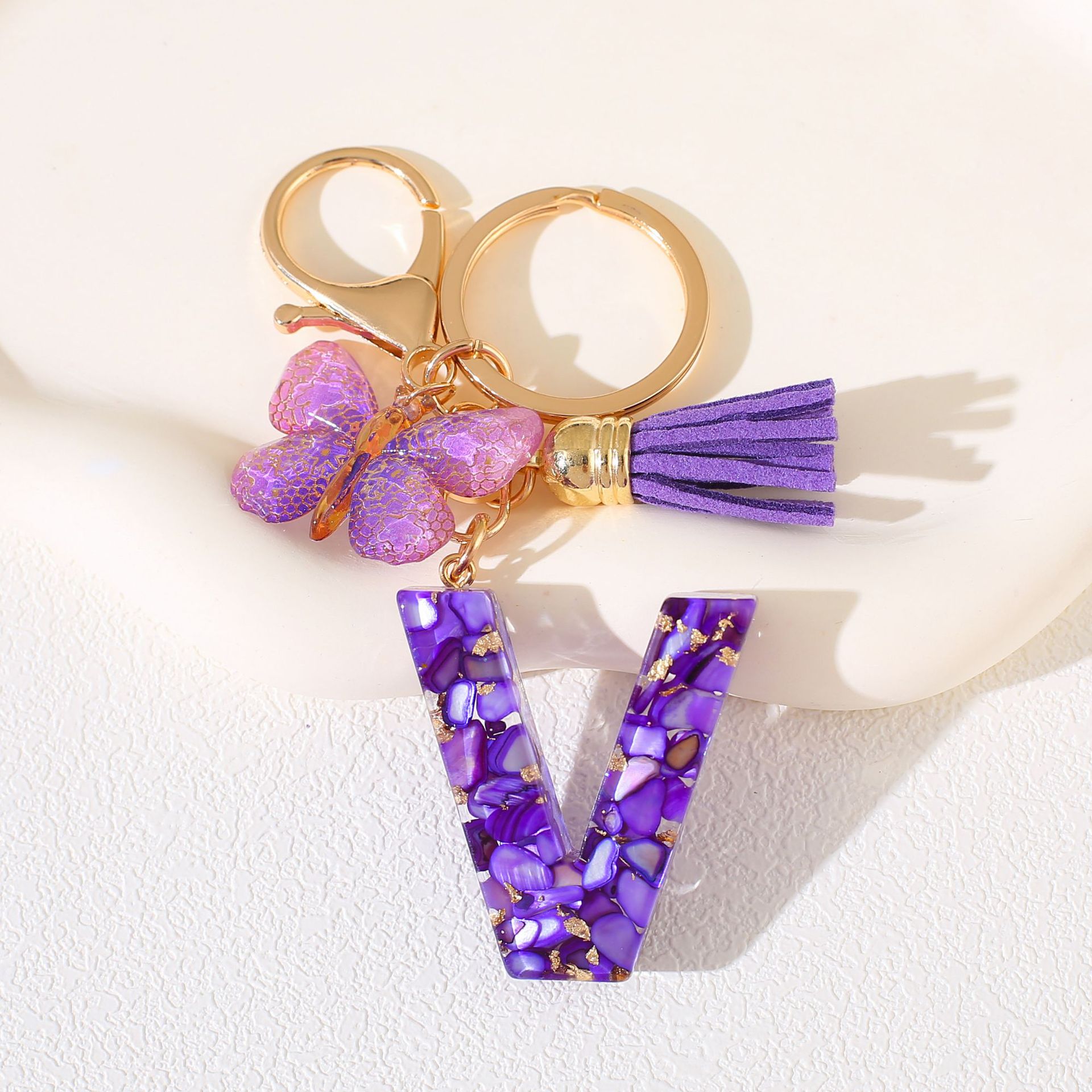 Fábrica directa de Yiwu accesorios de resina de goteo de embalaje llavero anillo de metal letras mariposa brilla colgante damas