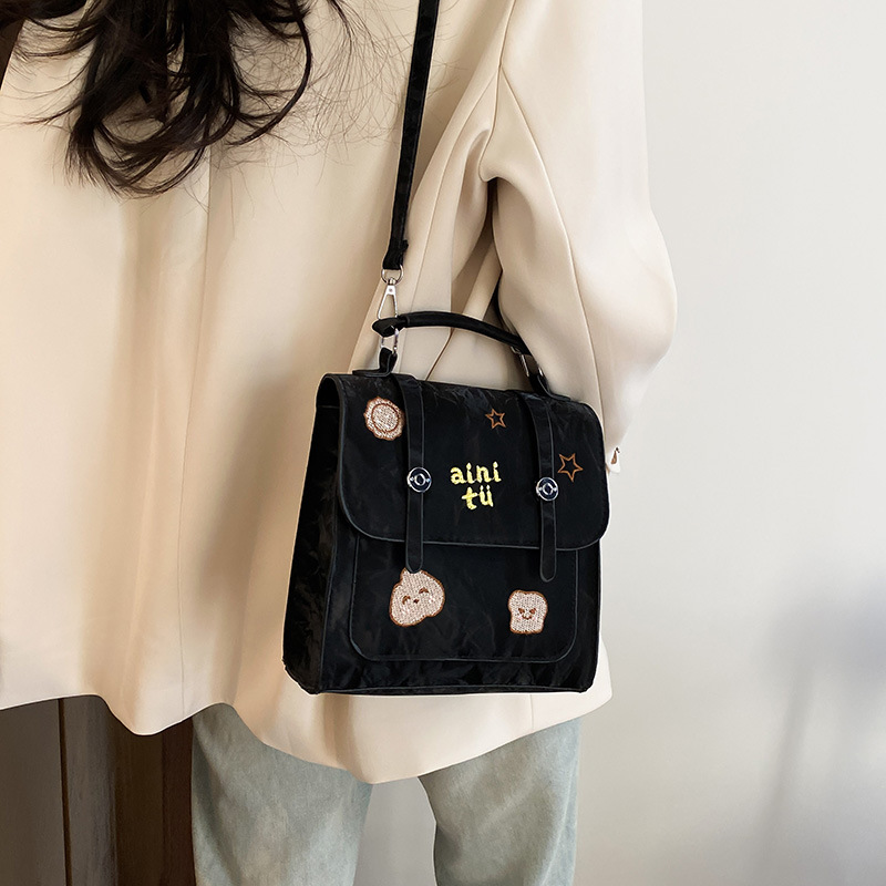 Bolsa universitaria viento rojo para mujeres 2025 nueva moda alta sensación de mochila de viaje universal mochila