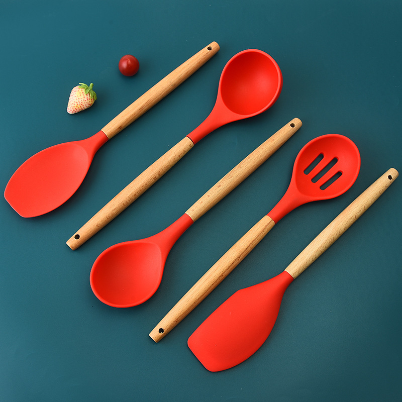 Traje de utensilios de cocina de silicona transfronteriza mango de madera sartén antiadherente de 12 piezas pala de cocina cuchara suministros de cocina espátula de silicona conjunto completo