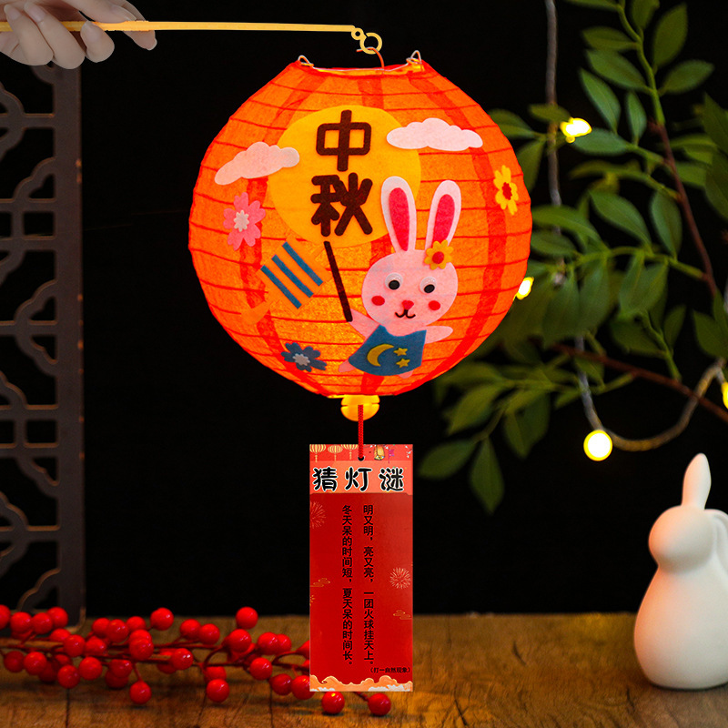 中秋節の紙提灯の漫画は手に持って光る露店の紙提灯の子供の手作りのdiy材料を持って幼稚園を包みます。|undefined