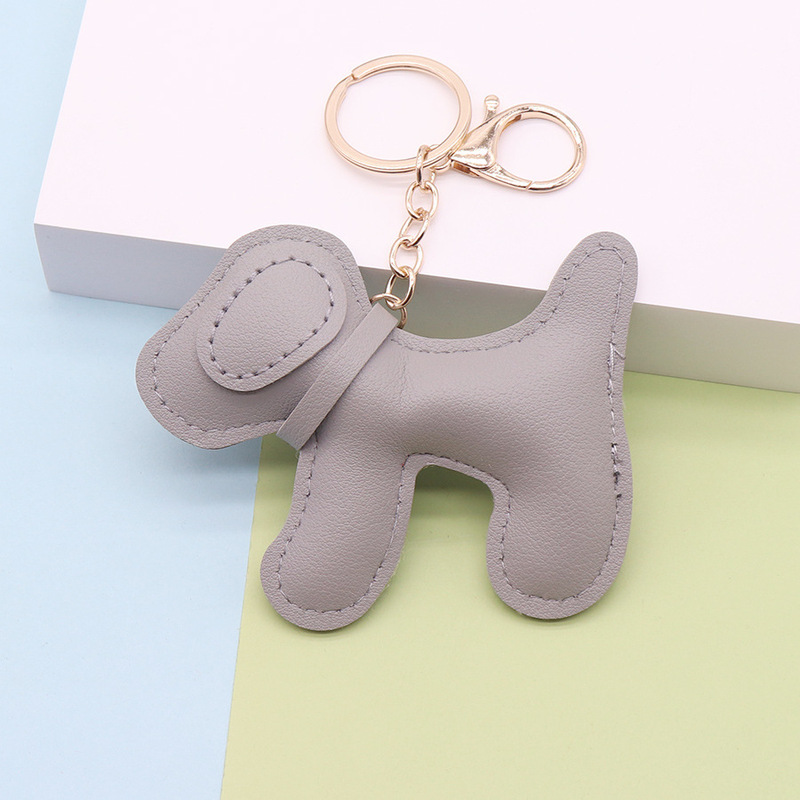 多色の創意的な子犬の鍵は革の掛け物を掛けます。|undefined
