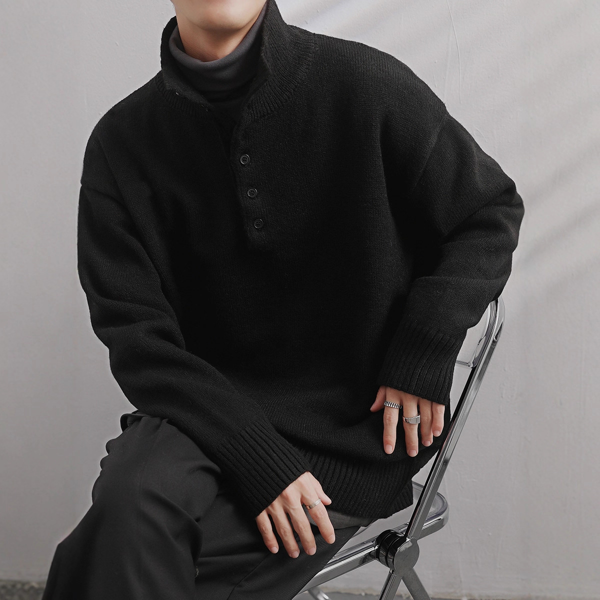 Medio cuello alto 2025, otoño y invierno, camiseta de punto de color sólido, diseño de cuello de botón, suéter de personalidad, chaqueta suelta para hombres