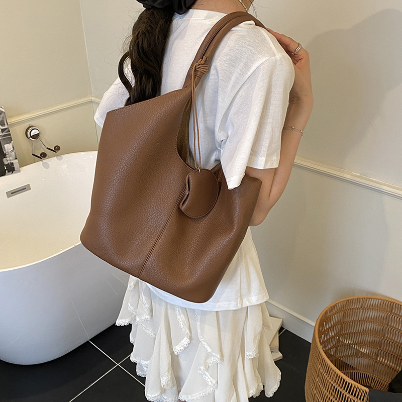 Bolso de cubo de axila de estilo explosivo transfronterizo para mujer 2025 nuevo bolso de hombro de cuero suave de viajero salvaje simple bolso de niño y madre de todo fósforo