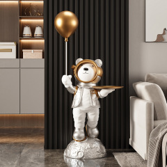 宇宙熊が床に落ちて収納してリビングルームのホテルのクラブのテレビの棚のそばの装飾品を飾って贈り物の工芸品に移ります。