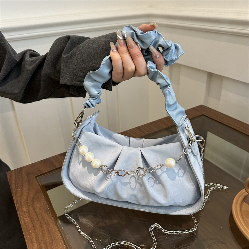 Diseño de nicho francés 2024 nuevo color sólido simple cadena de perlas de aire extranjero plegado versátil bolso de mochila pequeña moda
