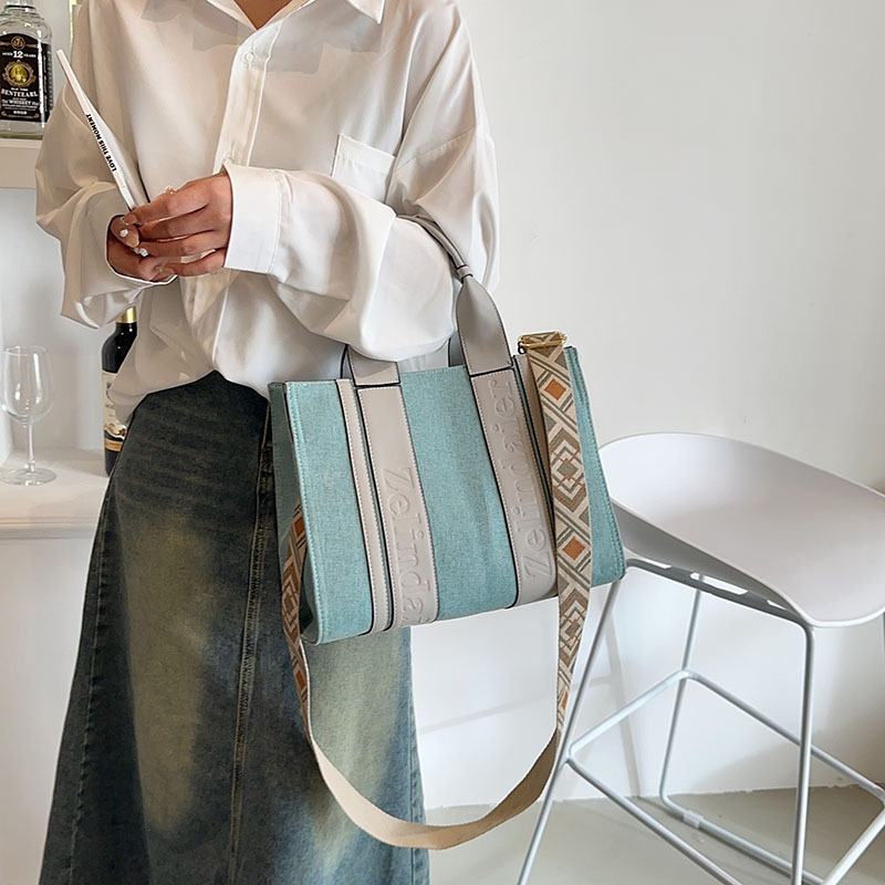 Bolso tote de lona de nuevo estilo con bloques de color, de gran capacidad para mujer, bolso cruzado de moda transfronteriza con sensación de alta gama para el trabajo y el transporte diario.
