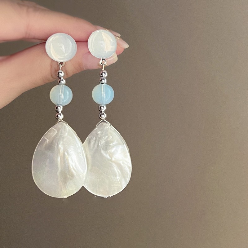 Pendientes de borla de concha blanca redonda con aguja de plata Pendientes de todo fósforo de moda de estilo de vacaciones Pendientes de alta gama de nicho al por mayor