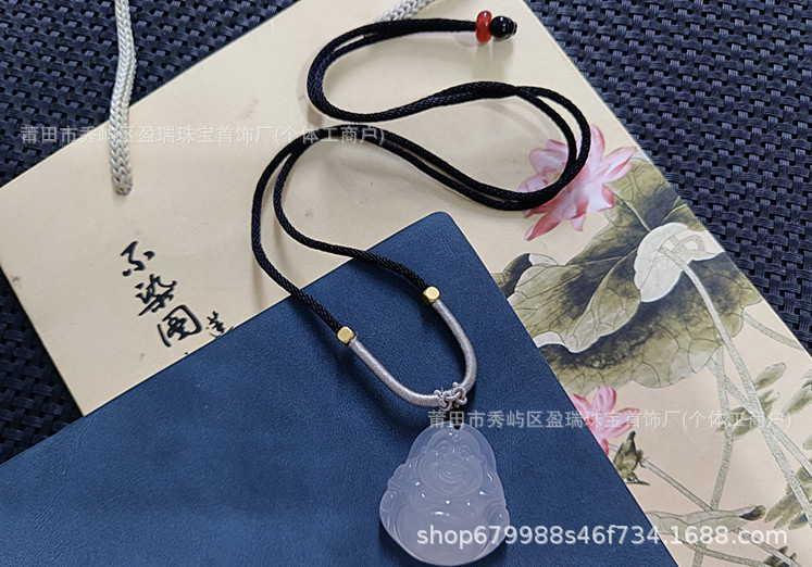 검정색과 회색 밧줄이 달린 흰색 칼세도니 부처님