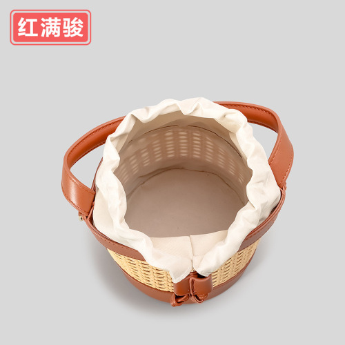 New handmade woven rattan bucket bag for women: chic hollowed-out drawstring tote perfect for beach vacations, also a unique choice as a shoulder or crossbody bag.