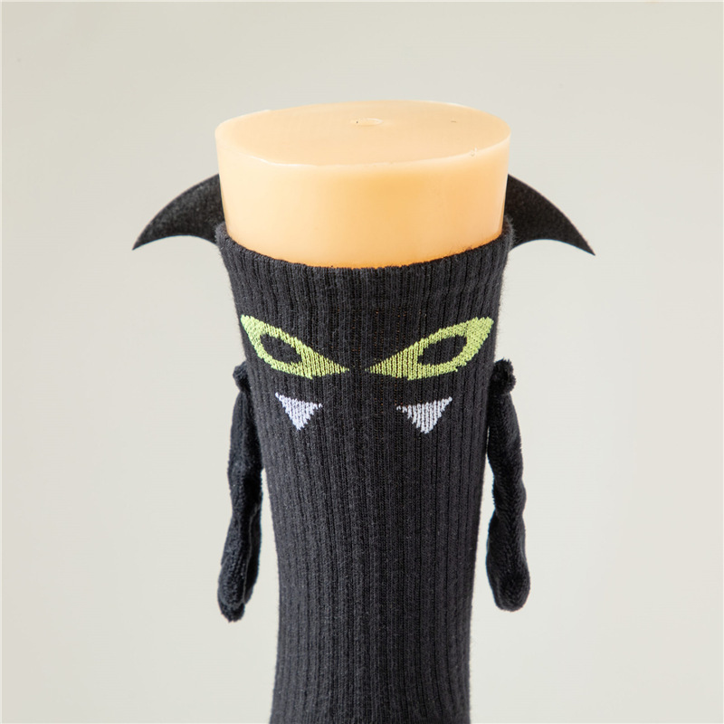 ハロウィーンの靴下の幽霊の磁気は手をつないで靴下を越えてアマゾンを越えてかわいいコウモリの靴下の中で靴下の綿をいじります。|undefined