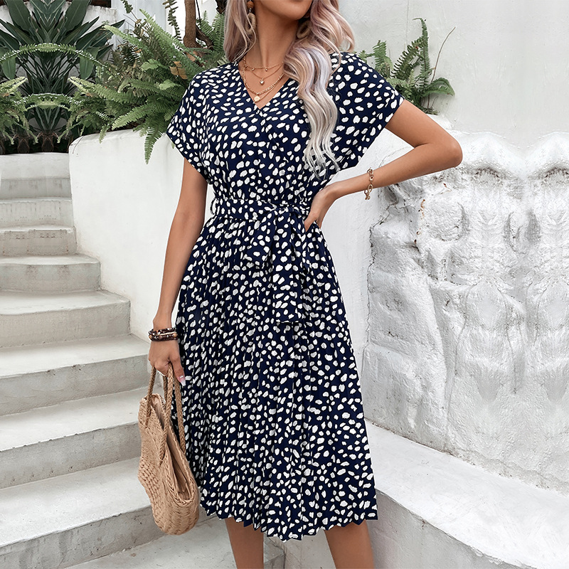 Woman wearing a navy dress with white florals as a wedding guest