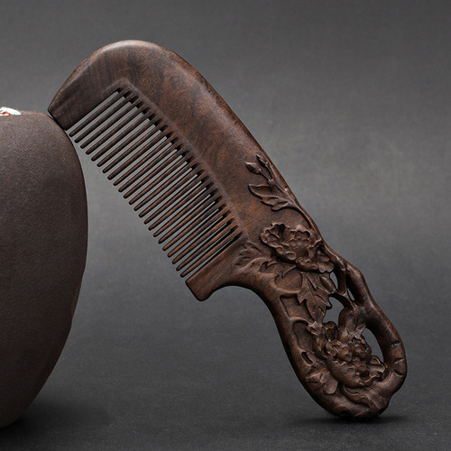 A solid wood hair comb with a black sandalwood handle, double-sided carved floral design, fine-toothed, ancient-style gift comb for smooth hair and massage.
