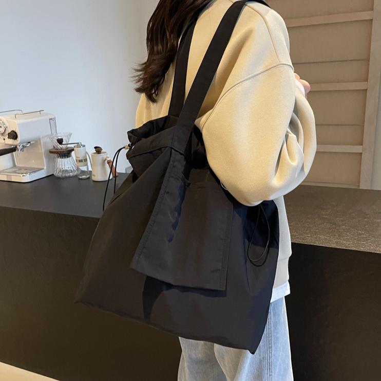 Bolsa de tela de nylon impermeable para mujeres 2025 nuevo tipo bolso de cubo de viaje ligero de gran capacidad bolso de hombro portátil para estudiantes universitarios