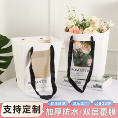 花屋の花の包装ネットの赤い台形は窓を開けて袋の大きいサイズの贈り物の袋を抱いてバラの花の手提げの贈り物の袋の卸売りを持ちます。