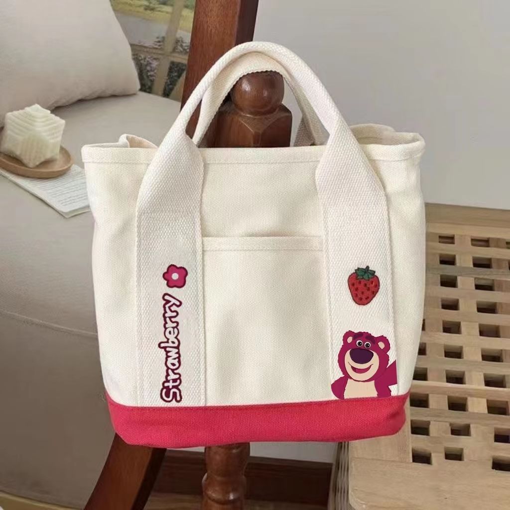 A small handbag is carried by a female student going out. She is carrying a 2024 new style bag, a mini canvas bag, and a Korean version bento bag for female students undefined