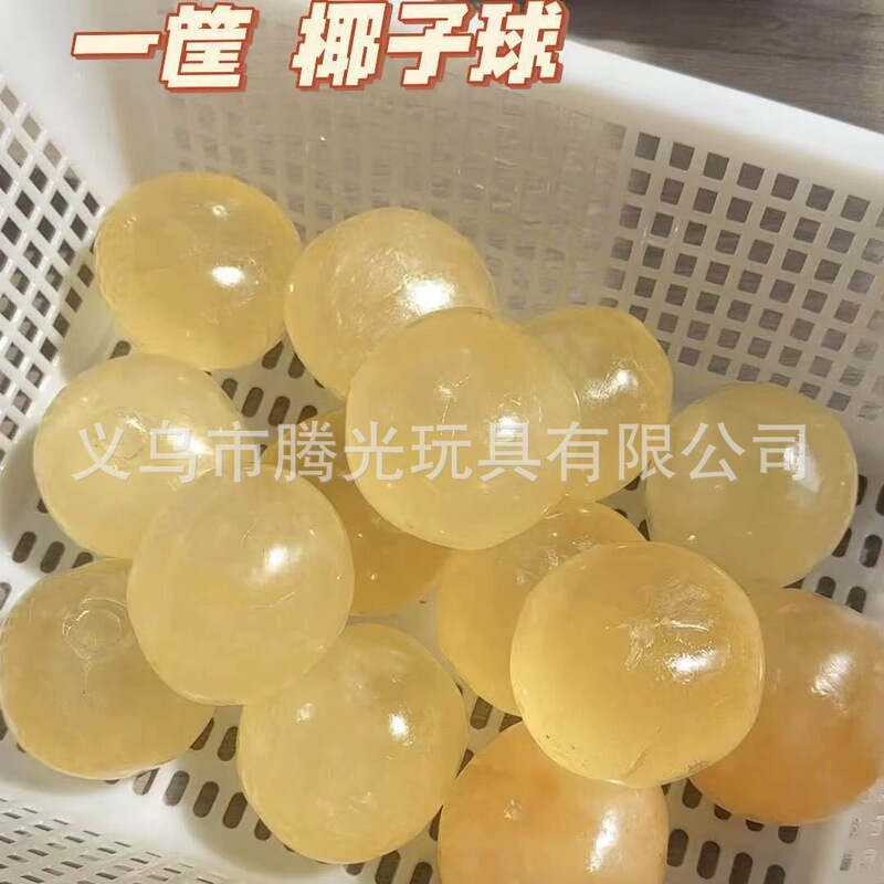 ネットの赤い爆発のココナッツの油の手はボールをつまんでゆっくりとボールをつまんで手でおもちゃの子供のプレゼントを解凍します。|undefined