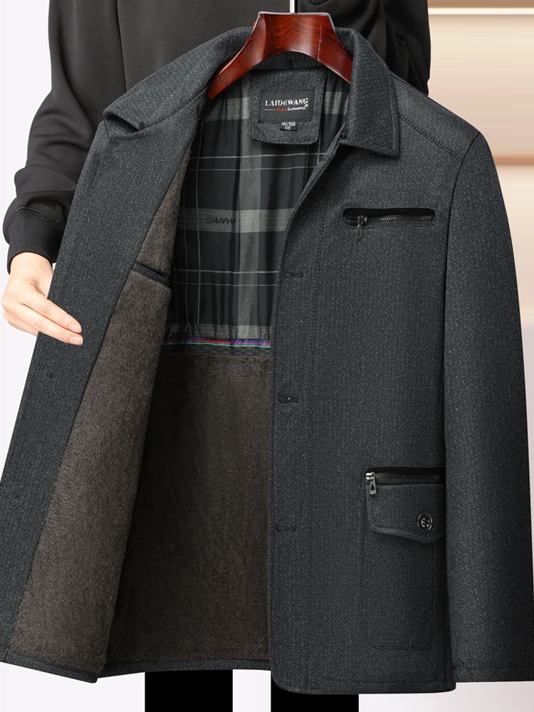 秋冬の中高年のメンズとベルベットのコートのお父さんはビジネス服の中年の男性の厚いジャケットの上着を襟を返します。