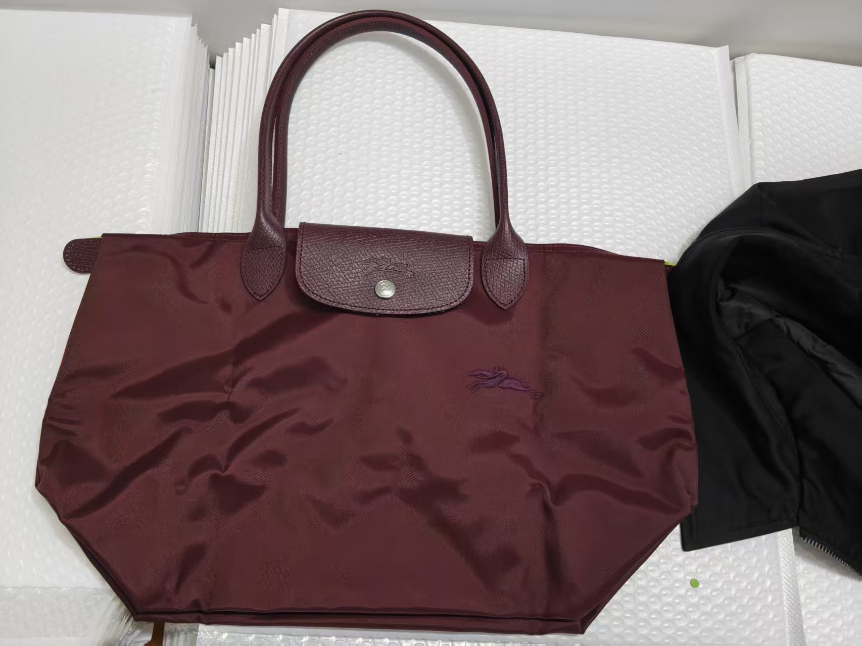 フランスの竜は高く上げてナイロンのカバンを包んで、女性のカバンの長い柄はギョーザの包みを持って折り畳みます。